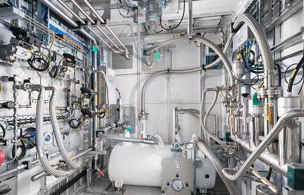 Technical hydrogen liquefaction system with pipes, valves and insulated equipment inside the HIP facility.